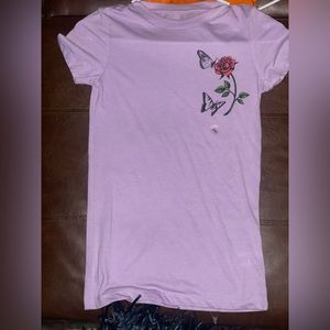 Purple H&M shirt. Rose at top of the corner.